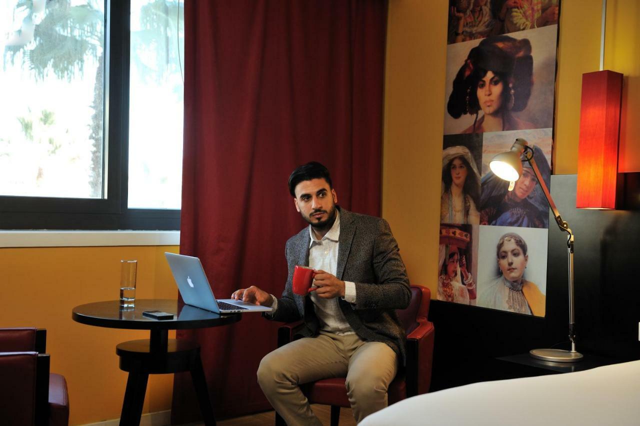 Hotel Mercure Alger Aeroport Dar el Beïda Kültér fotó A man working on a laptop